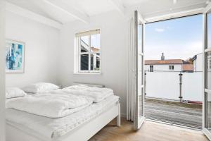 une chambre blanche avec un lit et une grande fenêtre dans l'établissement TV1280-Bindslev-Tannisbugtvej-49-D-Nr-5, à Bindslev