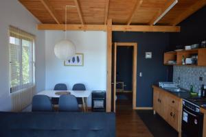 a kitchen and dining room with a table and chairs at Valdivia, Cabañas camino a Niebla in Valdivia
