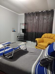 un soggiorno con tavolo e divano giallo di DEPARATAMENTO PREMIUM CON 2 HABITACIONES DOBLEs a Tacna