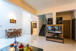 a living room with a television and a table at Aneesha Bunglow in Mahabaleshwar