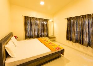 a bedroom with a large bed with a window at Aneesha Bunglow in Mahabaleshwar