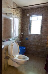 a bathroom with a toilet and a window at Aneesha Bunglow in Mahabaleshwar +23 photos