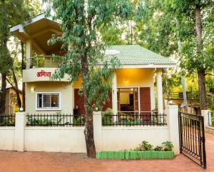 a house with a tree in front of it at Aneesha Bunglow in Mahabaleshwar