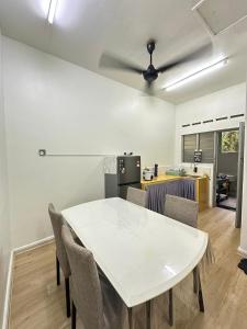 a kitchen and dining room with a white table and chairs at Homestay Mak 'Ndek '6' in Tangkak