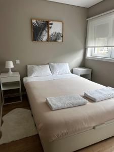 a bedroom with a bed with two pillows on it at Apartamento Parque da Cidade in Porto