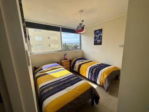 two beds in a room with a window at Comfortable Family Apartment in Mirasol