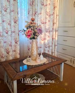 eine Vase mit Blumen auf einem Tisch in einem Zimmer in der Unterkunft Villa Ximena in Puno