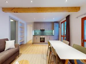 a kitchen and living room with a table and a couch at Apartment in Les Agettes with ski storage in Agettes
