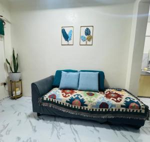 a living room with a couch with a colorful blanket at MiKasa Azul Transient House in Cabuyao