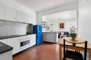 a kitchen with white cabinets and a blue refrigerator at Water views in Cowes