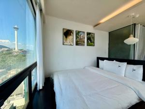 a bedroom with a white bed and a large window at Mini Hotel May Nampo in Busan