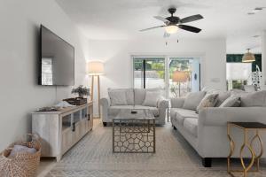 a living room with a couch and a tv at Stylish Home near Anna Maria Island Beaches - Heated Pool - Oasis in Bradenton +38 photos