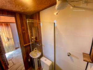 a bathroom with a toilet and a shower and a sink at Casa Borba Chalé Rústico in Alto Paraíso de Goiás +26 photos