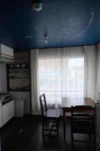 Una cocina con mesa y sillas y una ventana. en めくる, en Matsumoto