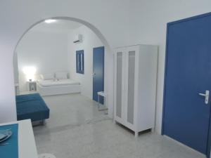 ポロニアにあるJorgos studiosの白と青の客室で、ベッド1台、バスルームが備わります。