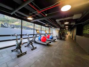 a gym with cardio equipment in a room with windows at AH/Luxe penthouse con balcón,Wifi+Parking; Usaquén in Bogotá