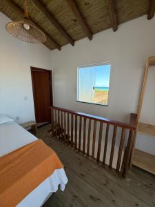 un dormitorio con una cama y una ventana en Vila Viver Caraíva, en Caraíva