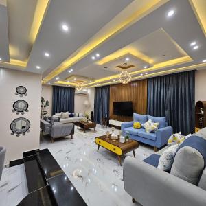 a large living room with blue couches and a tv at مدينة السادس من اكتوبر الحي السابع in 6th Of October