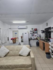a living room with a couch and a kitchen at บ้านพักอู้ฟู่ in Na Jomtien +17 photos