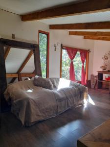 a bedroom with a bed in a room with windows at collico lodge in Villarrica