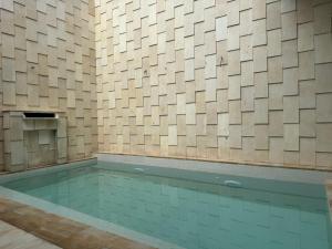 a swimming pool in a room with a tile wall at i Two Panorama Villas in Batu