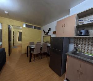 a kitchen with a black refrigerator and a table at Cozy 2BR Deca Homes, Near Airport, SM Jmall, SM Cebu & Parkmall in Mandaue City