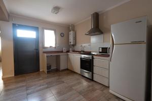 a kitchen with a white refrigerator and a stove at Departamento familiar a estrenar in Las Parejas