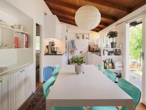 a dining room with a white table and blue chairs at 6 person holiday home in Tisvildeleje