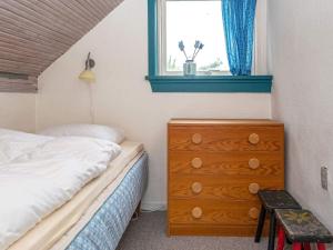 a bedroom with a bed and a dresser and a window at 3 person holiday home in Ringkøbing in Ringkøbing