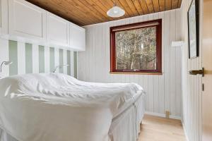 a bed in a room with a window at TV1651-Bindslev-Vestervej-54 in Bindslev