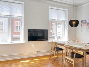 a dining room with a table and chairs and windows at 4 person holiday home in Nakskov-By Traum in Nakskov