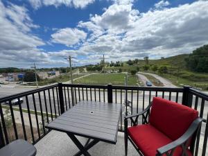 a red chair sitting on a balcony with a table at Stylish 2-Story Condo with Balcony in Kitchener