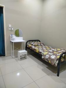 a bedroom with a bed and a table and a mirror at Stingless Bee Homestay in Kluang