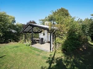 un cenador con una mesa de picnic en un campo en Tranquil Beach Retreat - By Traum, en Idestrup 29 fotos más