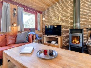 a living room with a table and a fireplace at 6 person holiday home in Blokhus-By Traum in Blokhus