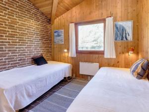 two beds in a room with a brick wall at 6 person holiday home in Blokhus-By Traum in Blokhus