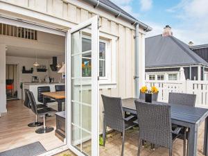 a patio with a table and chairs and a kitchen at 6 person holiday home in Ringkøbing in Ringkøbing