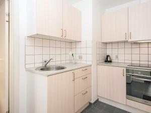 a kitchen with white cabinets and a sink at Holiday apartment near town square in Ringkøbing