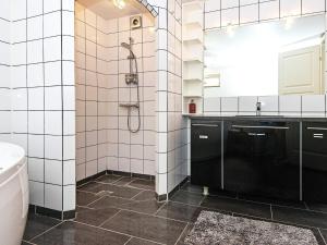 a white tiled bathroom with a shower and a sink at Holiday home in Ebeltoft with roof terrace in Ebeltoft +28 photos
