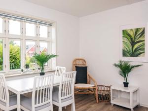 a white dining room with a white table and chairs at Charming Retreat in Ringkobing in Ringkøbing