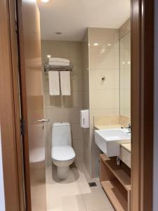 a bathroom with a toilet and a sink at Fabuloso Hotel Alvorada - Apt da Rede Premium in Brasilia