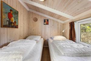 two beds in a room with wooden walls at TV1660-Albaek-Lyngstien-6-A in Ålbæk +22 photos