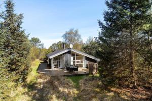 a small cabin in the middle of a forest at TV1660-Albaek-Lyngstien-6-A in Ålbæk