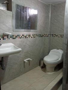 a bathroom with a toilet and a sink at apartamento esmeralda zipaquira in Zipaquirá