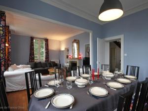 a dining room table with plates and wine glasses at Maison de maître 19ème, parc arboré et cheminée, centre L'Aigle - FR-1-497-57 in LʼAigle