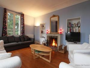 a living room with a couch and a fireplace at Maison de maître 19ème, parc arboré et cheminée, centre L'Aigle - FR-1-497-57 in LʼAigle