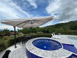 a dog sitting under an umbrella next to a pool at Casa Quinta Arbelaez in Arbeláez