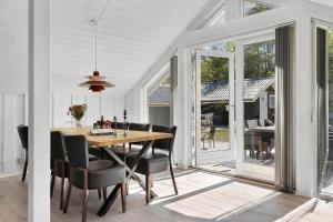 ein Esszimmer mit einem Holztisch und Stühlen in der Unterkunft TV1661 Jerup - Blåbærvej 5 in Jerup