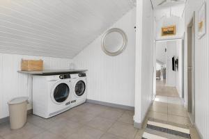 eine Waschmaschine und einen Trockner in einem weißen Zimmer in der Unterkunft TV1661 Jerup - Blåbærvej 5 in Jerup