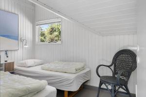 ein Schlafzimmer mit zwei Betten, einem Stuhl und einem Fenster in der Unterkunft TV1661 Jerup - Blåbærvej 5 in Jerup